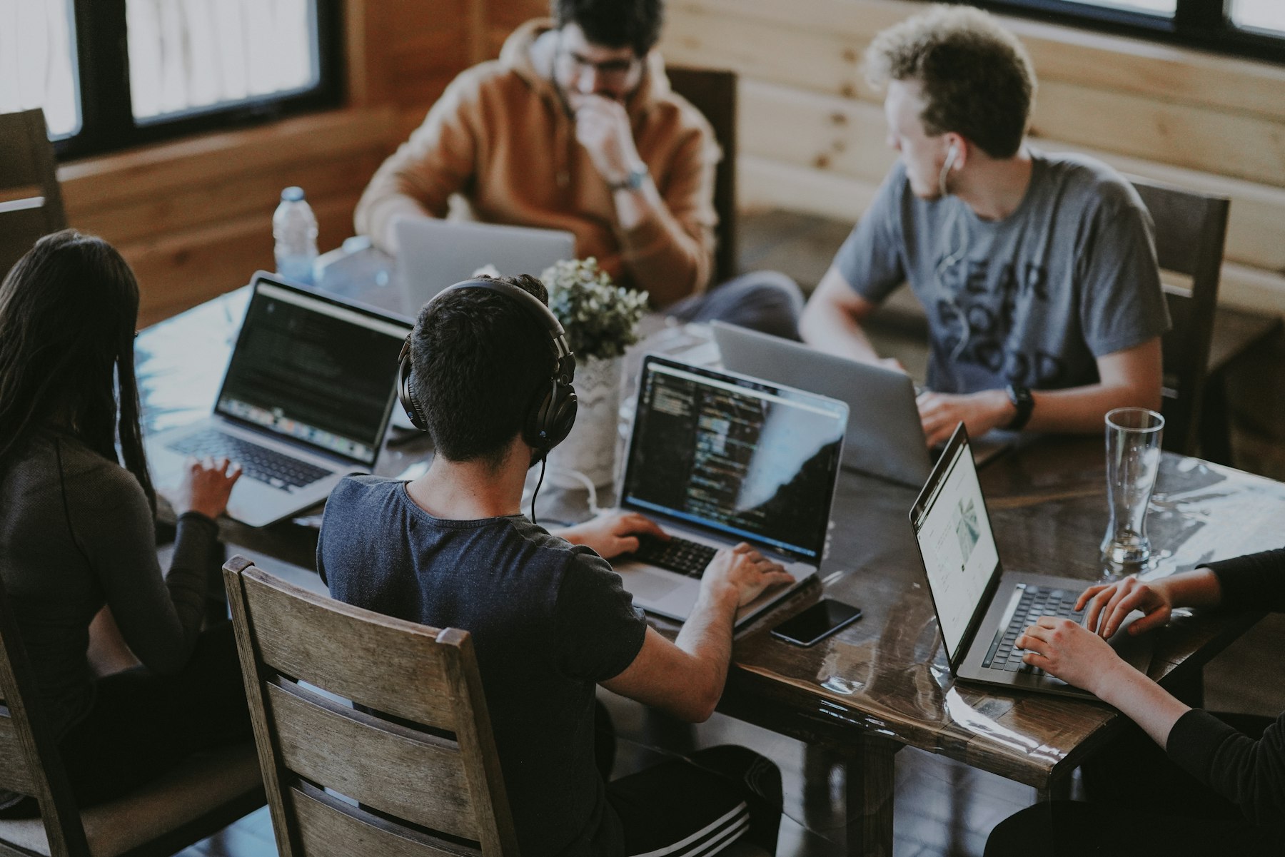 Engineers working together around laptops at a long table